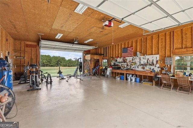 garage with a garage door opener and a workshop area