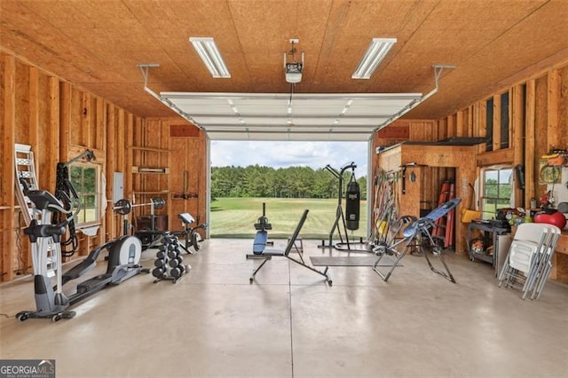 garage featuring a garage door opener and wooden walls