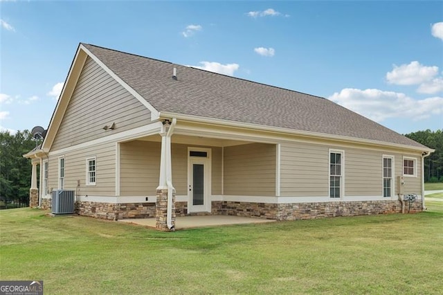 rear view of house with cooling unit, a yard, and a patio area