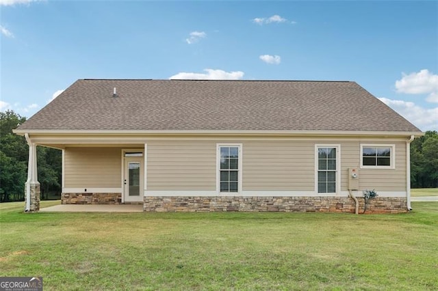 rear view of property featuring a yard and a patio area