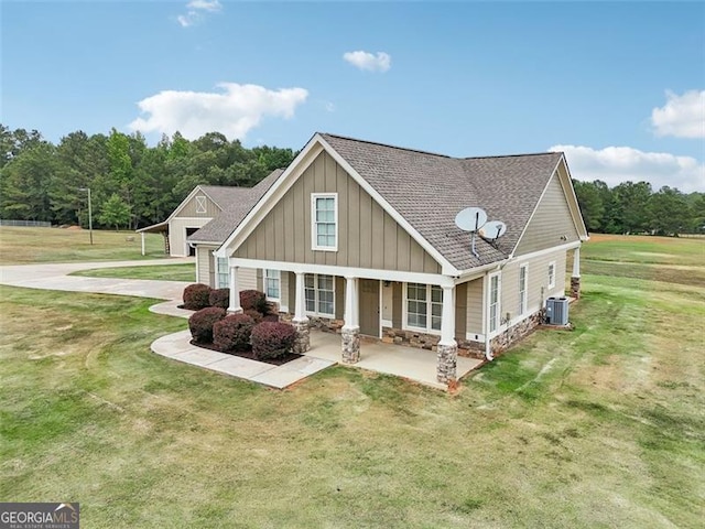 back of property featuring a yard, central AC unit, and covered porch