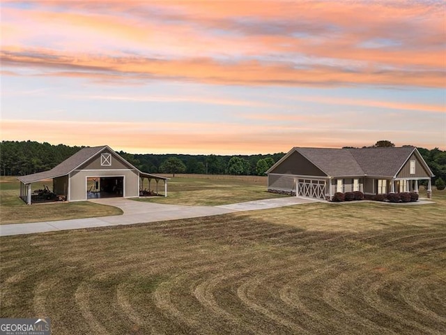 view of front facade featuring an outbuilding, a yard, and a garage