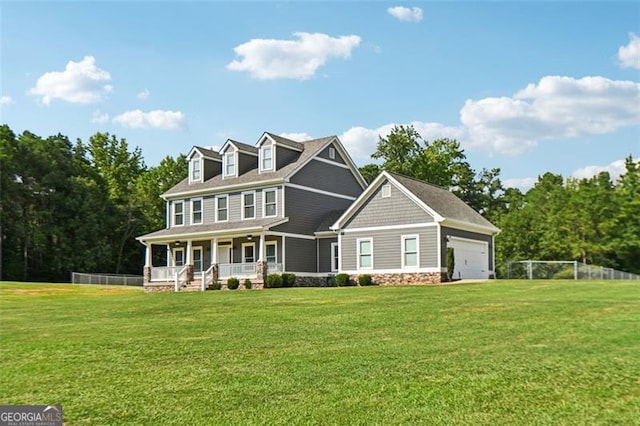 view of front of property with a garage, covered porch, and a front lawn