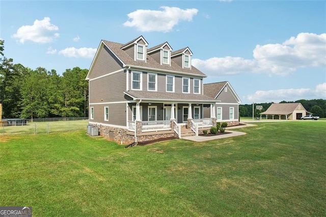 view of front of home featuring cooling unit, covered porch, and a front lawn