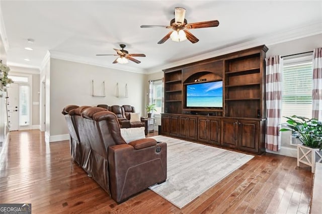 living room with crown molding, wood-type flooring, and ceiling fan