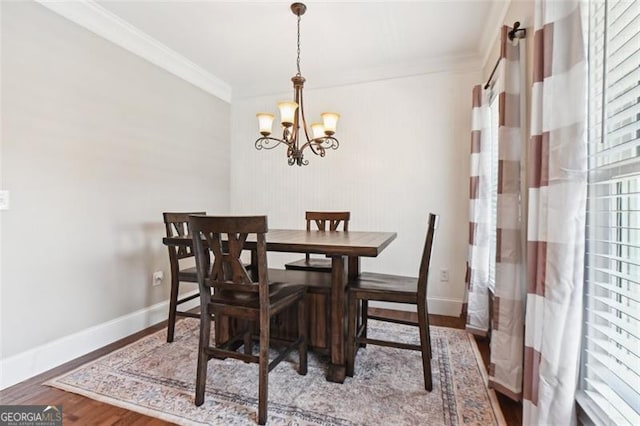 dining area with a notable chandelier, hardwood / wood-style flooring, and ornamental molding