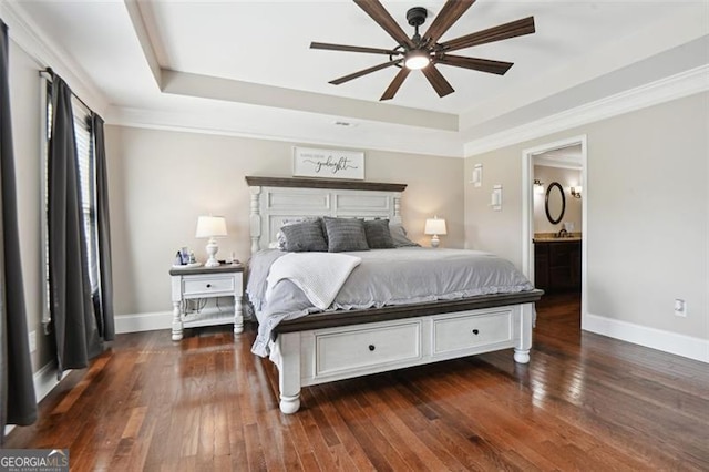 bedroom featuring dark hardwood / wood-style flooring, ceiling fan, and a tray ceiling