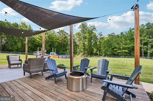 wooden deck featuring a lawn and an outdoor living space with a fire pit