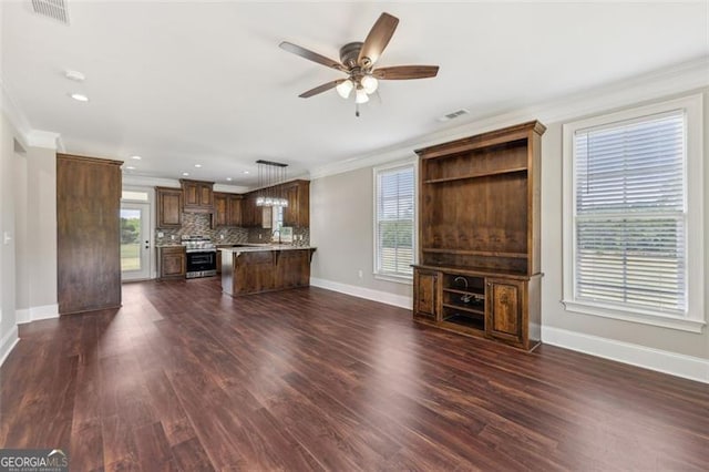 unfurnished living room featuring dark hardwood / wood-style flooring, crown molding, and ceiling fan