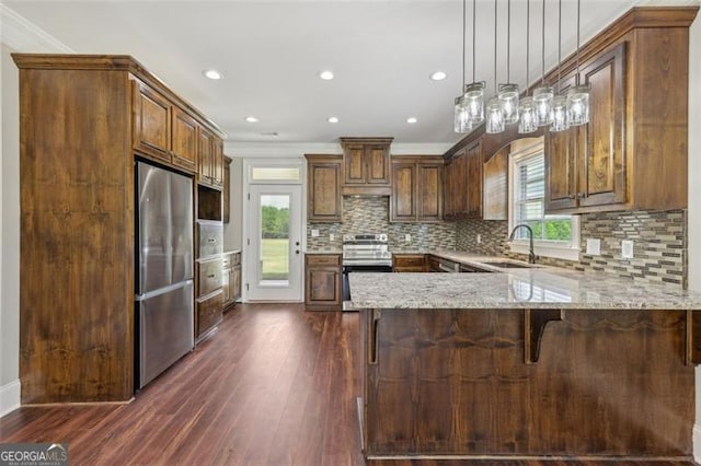 kitchen featuring dark hardwood / wood-style flooring, a wealth of natural light, stainless steel appliances, and kitchen peninsula