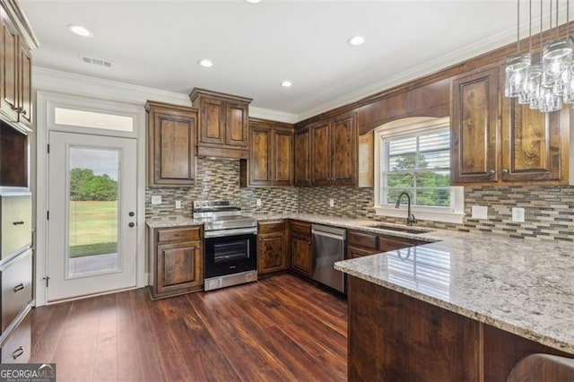 kitchen with sink, crown molding, decorative light fixtures, appliances with stainless steel finishes, and light stone countertops