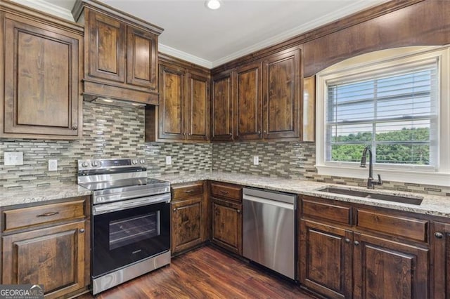 kitchen featuring appliances with stainless steel finishes, sink, backsplash, light stone countertops, and dark wood-type flooring