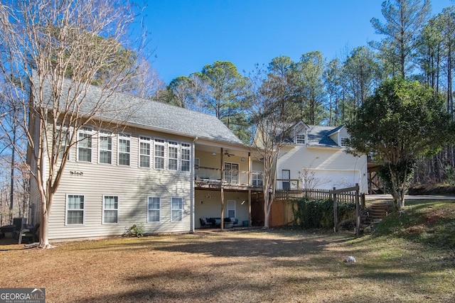 back of property featuring ceiling fan and a lawn