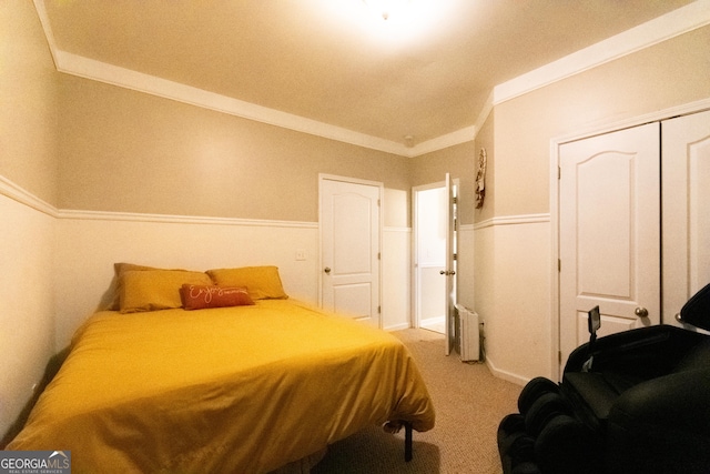 carpeted bedroom featuring a closet, radiator, and crown molding