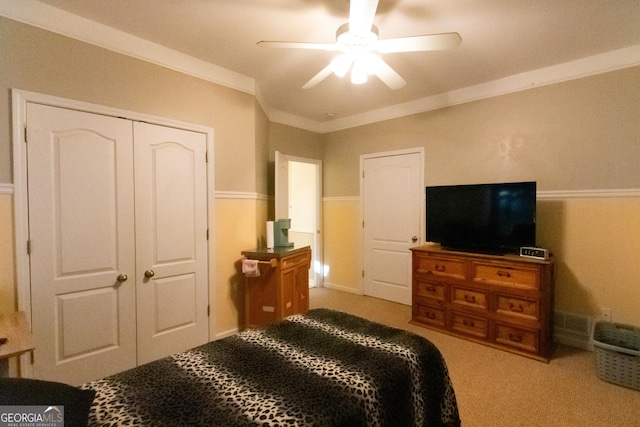 bedroom with ceiling fan, a closet, carpet floors, and crown molding