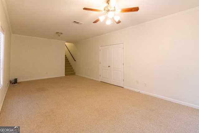 carpeted empty room featuring ceiling fan and ornamental molding