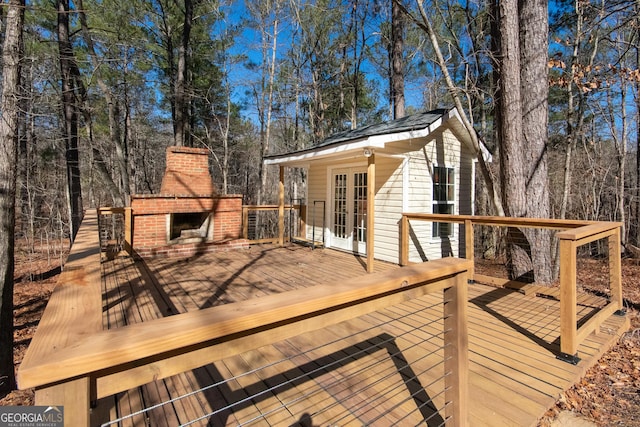 deck with an outdoor brick fireplace