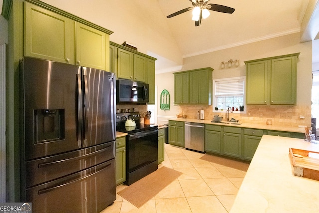 kitchen with sink, green cabinetry, light tile patterned floors, and appliances with stainless steel finishes