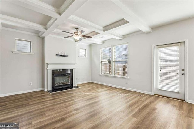 unfurnished living room featuring hardwood / wood-style flooring, a healthy amount of sunlight, beamed ceiling, and coffered ceiling