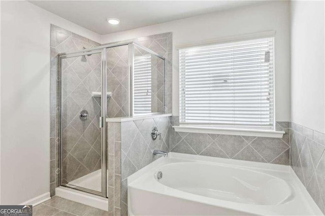 bathroom with independent shower and bath, plenty of natural light, and tile patterned flooring