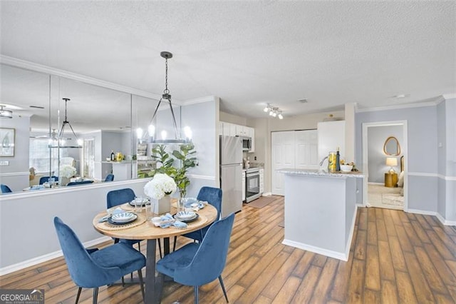 dining space featuring crown molding, hardwood / wood-style floors, and a textured ceiling