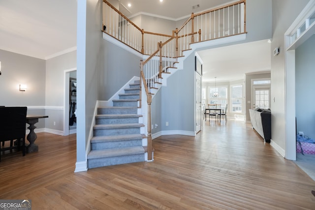 stairway featuring crown molding and hardwood / wood-style floors