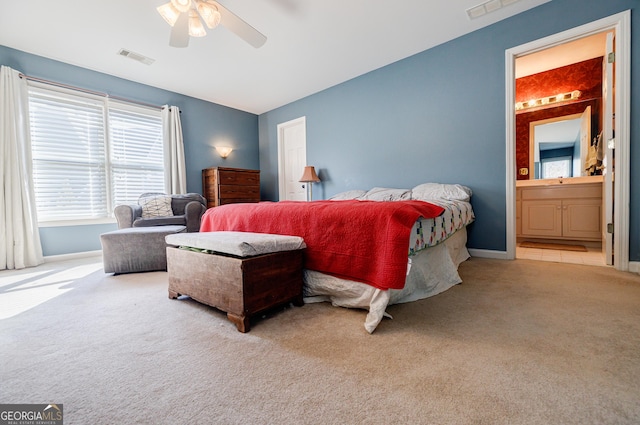 carpeted bedroom with ceiling fan and ensuite bath