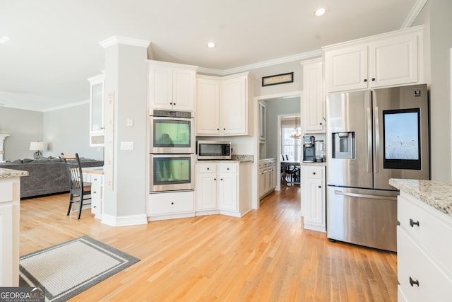 kitchen with light stone counters, white cabinets, and appliances with stainless steel finishes