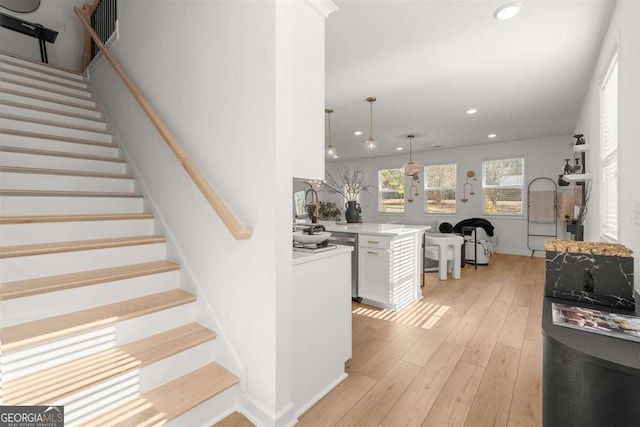 staircase featuring sink and hardwood / wood-style floors