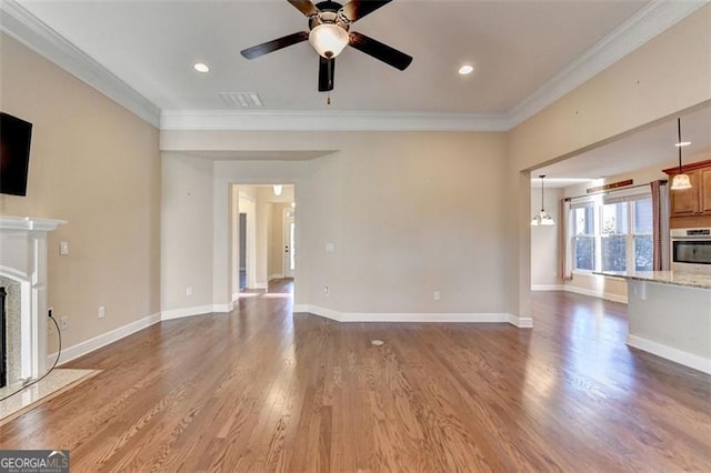 unfurnished living room featuring ornamental molding, a fireplace, wood finished floors, and baseboards