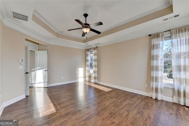 empty room featuring visible vents, a tray ceiling, and ornamental molding