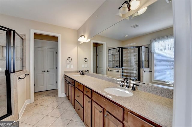 bathroom with a stall shower, tile patterned flooring, a sink, and double vanity