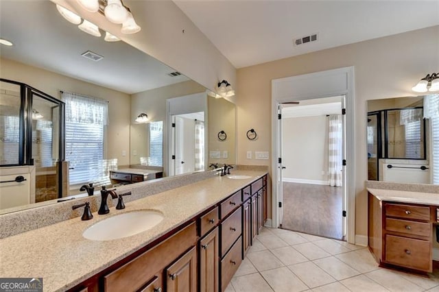 full bathroom featuring tile patterned flooring, visible vents, a sink, and a shower stall