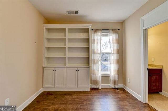 interior space featuring baseboards, visible vents, and dark wood-style flooring