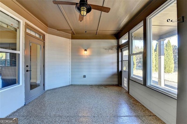 unfurnished sunroom featuring a wealth of natural light and ceiling fan