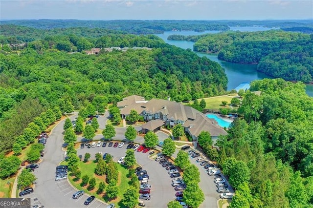 birds eye view of property with a water view and a wooded view