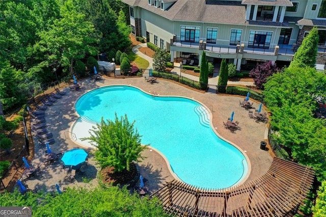 community pool featuring fence and a patio