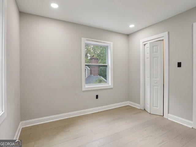unfurnished room with light wood-type flooring, recessed lighting, and baseboards