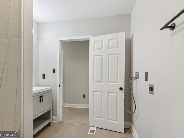 bathroom featuring wood finished floors, visible vents, vanity, and baseboards