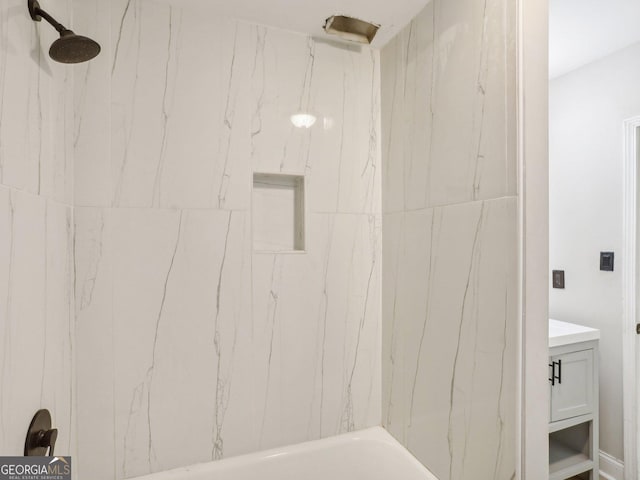 full bath featuring a marble finish shower and vanity
