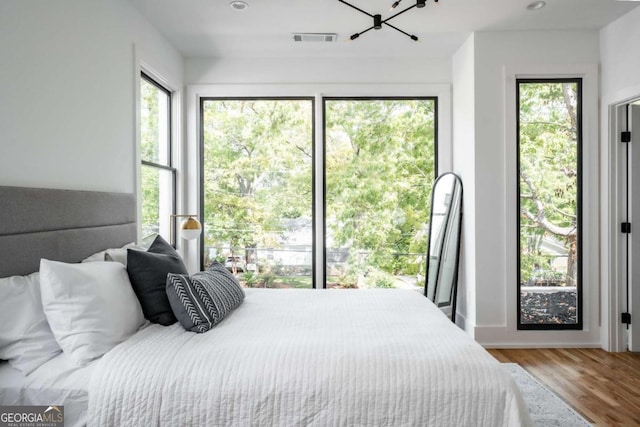 bedroom with wood-type flooring and multiple windows