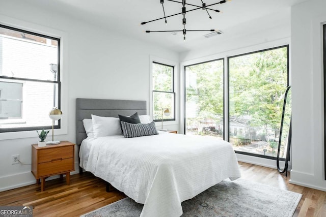 bedroom with multiple windows and light wood-type flooring