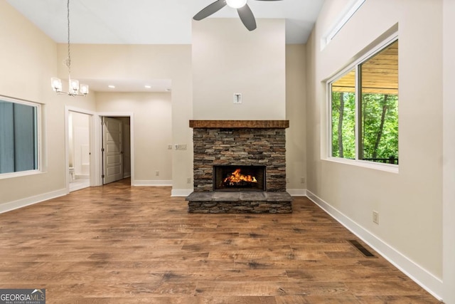 unfurnished living room with visible vents, a fireplace, baseboards, and wood finished floors