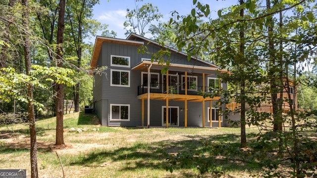 rear view of property featuring a yard and board and batten siding