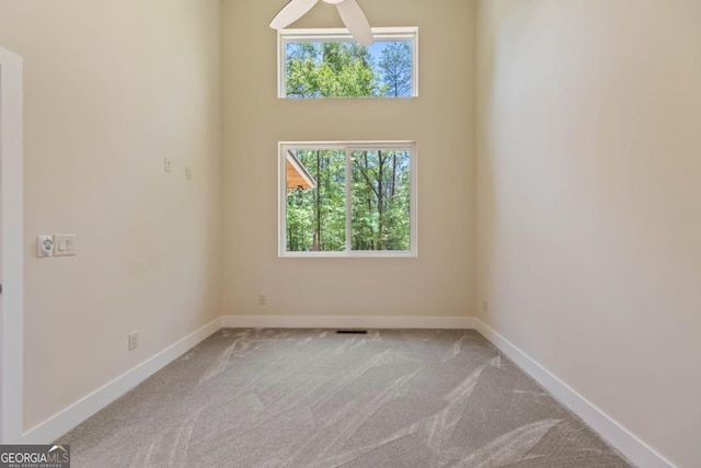 carpeted spare room featuring baseboards