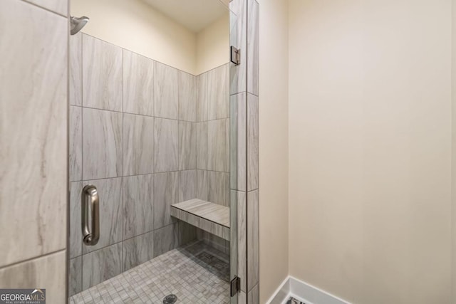 bathroom with a stall shower and baseboards