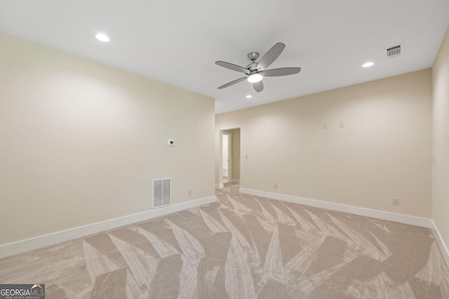 empty room featuring baseboards, visible vents, and light colored carpet