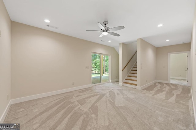 empty room featuring recessed lighting, light colored carpet, visible vents, baseboards, and stairs