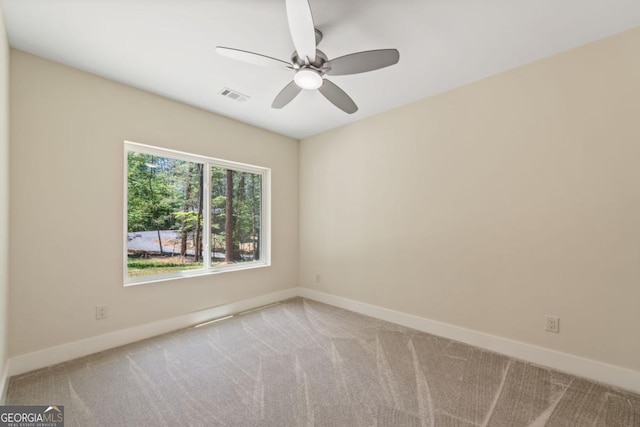 carpeted empty room featuring baseboards, visible vents, and a ceiling fan