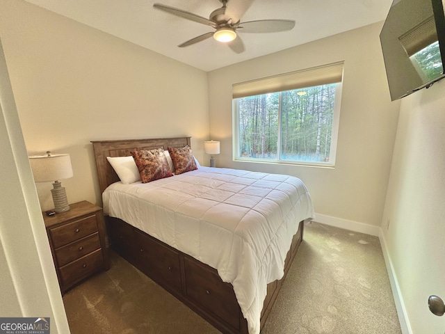 bedroom featuring baseboards, dark carpet, and a ceiling fan